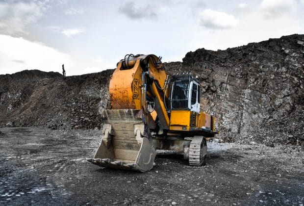 yellow and black excavator near hill