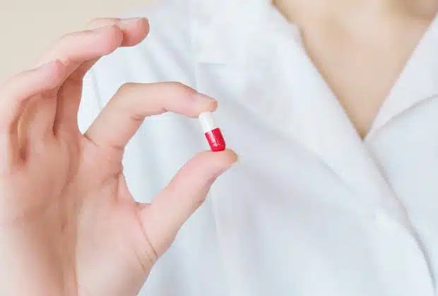 Crop nurse demonstrating small double colored pill