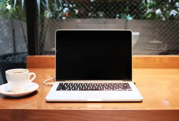 laptop computer beside coffee mug